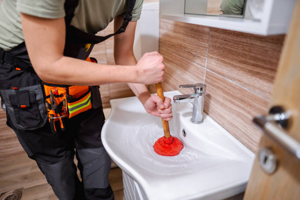 Profissional desentupindo pia com desentupidor manual em residência de Belo Horizonte